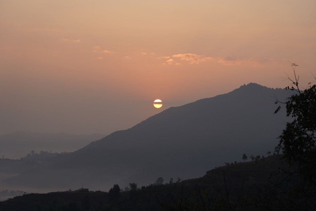 ネパールの朝に太陽が昇る。靄が強くてヒマラヤを見ることはできなかったが、と...