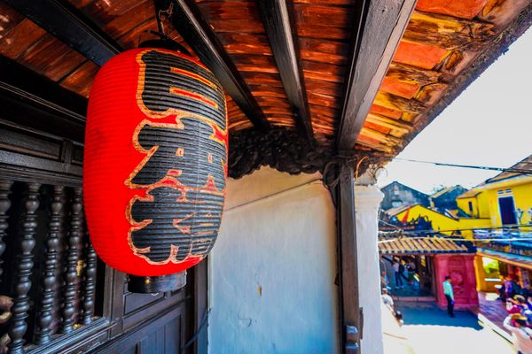 ベトナム・ダナン「ベトナム　ダナン・ホイアン」の写真：日本橋を渡ると黒い建物の前に人だかりがで...