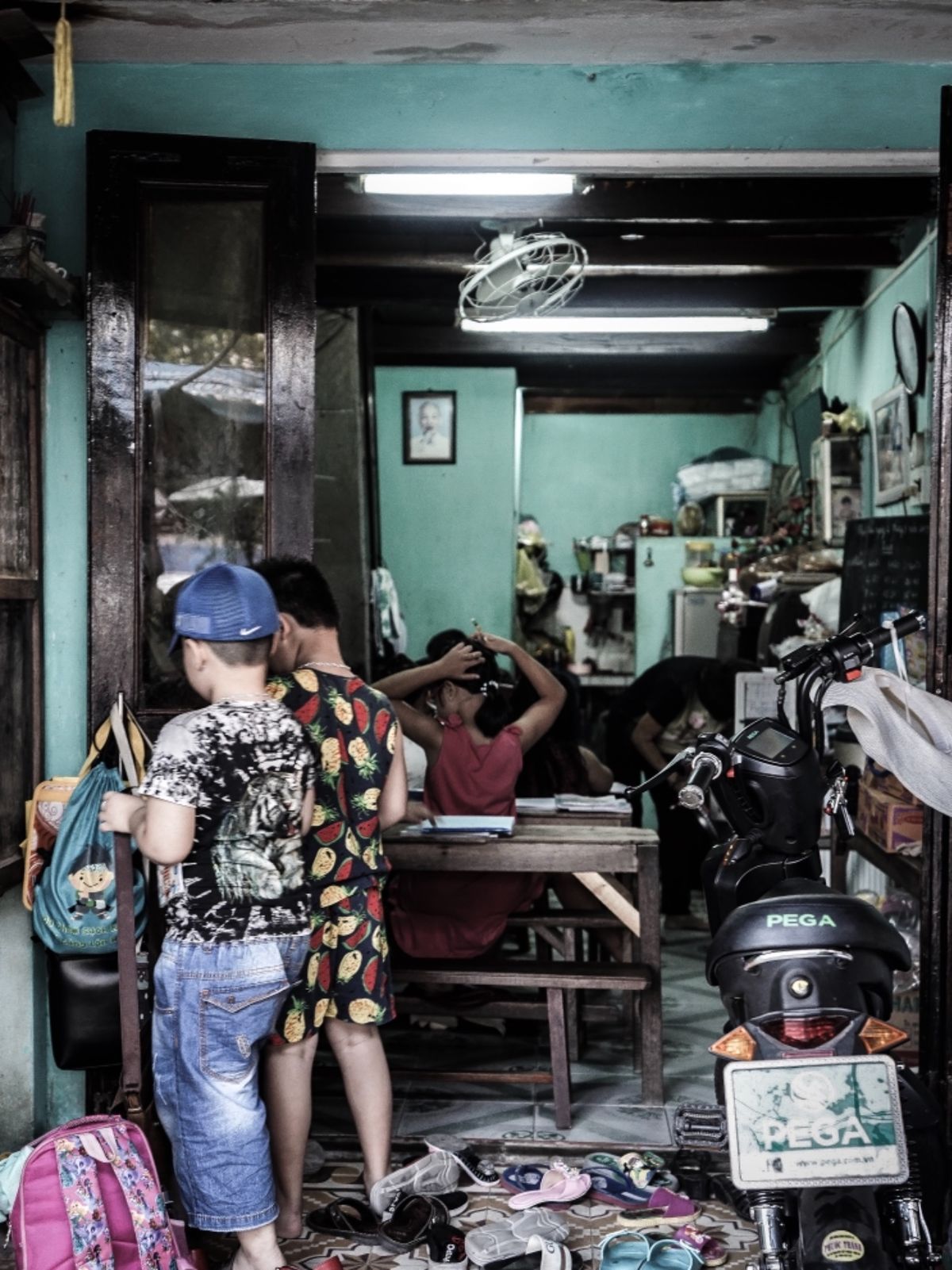 ホイアンの学習塾。午後4時。放課後。子供達が靴を脱ぎ捨てて教室に入っていく。