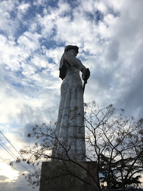 ジョージア・Tbilisi「ワインとヒンカリ」の写真：ジョージの母像と、暮れゆくトビリシの街です。