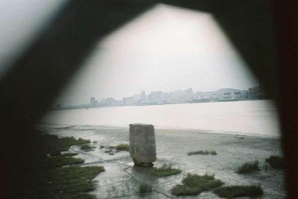 朝鮮民主主義人民共和国・DMZ「2005年金正日政権下の北朝鮮」の写真：中朝国境の橋を渡る。
川の向こうは丹東