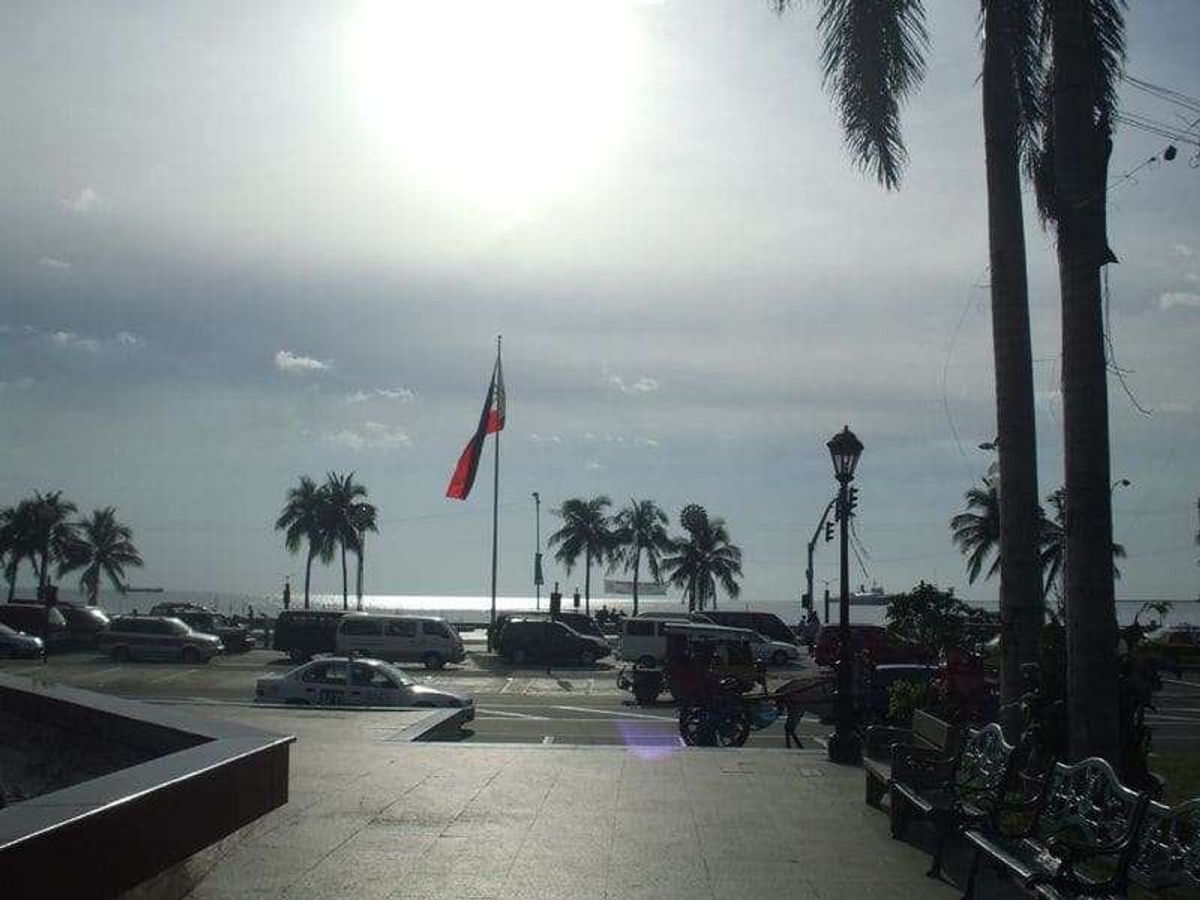 はためくフィリピン国旗とマニラ湾