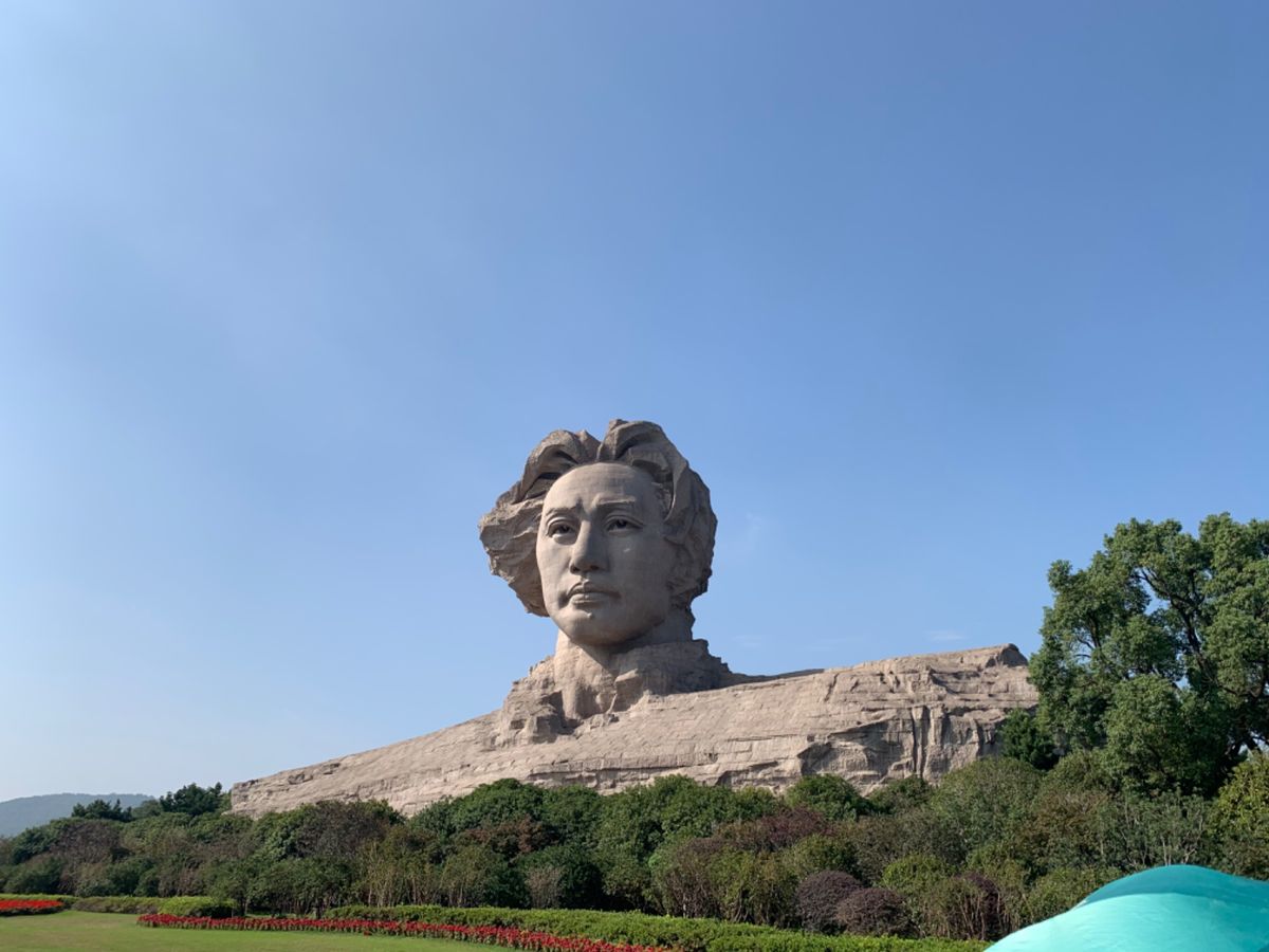 毛沢東の巨大な像。
像の前には真っ赤な看板に黄色字で、
「民達は、健康で、...