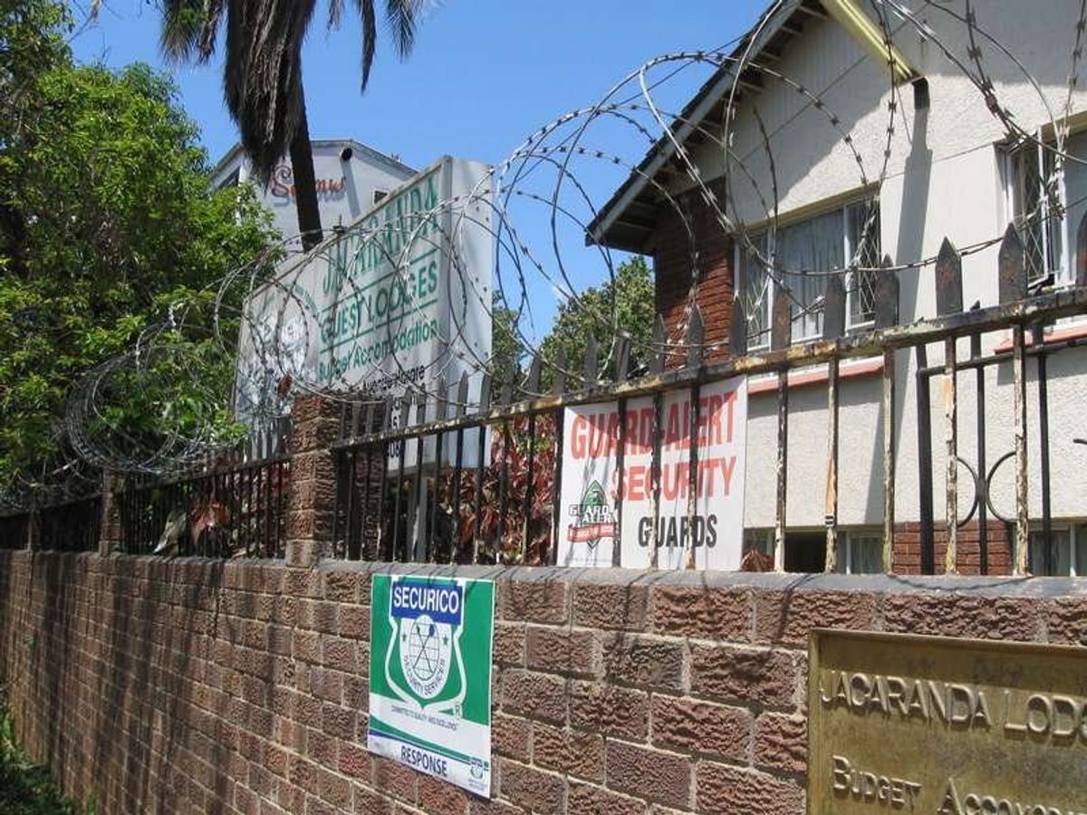 夜間は警備員が門に常駐。壁は鉄条網がグルグル巻きです。